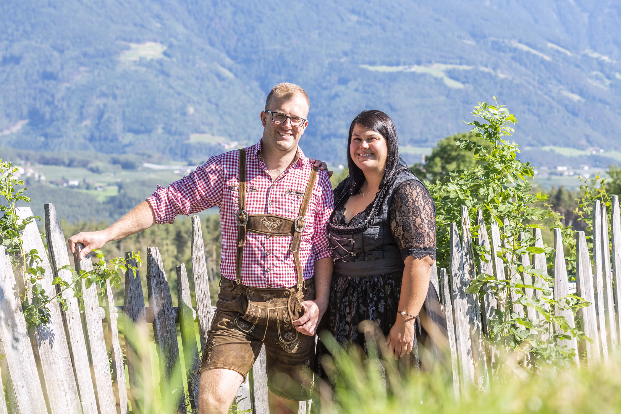 Die Familie Brunnerhof, Besitzer des Bauernhofs im Pustertal, lächelt glücklich inmitten der Natur Südtirols.