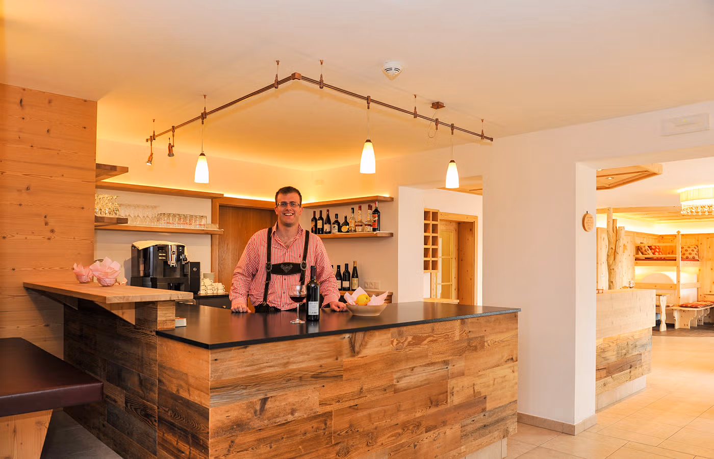 Der Sohn der Besitzer hinter der Theke der Naturholzbar des Agriturismo Brunnerhof im Pustertal.