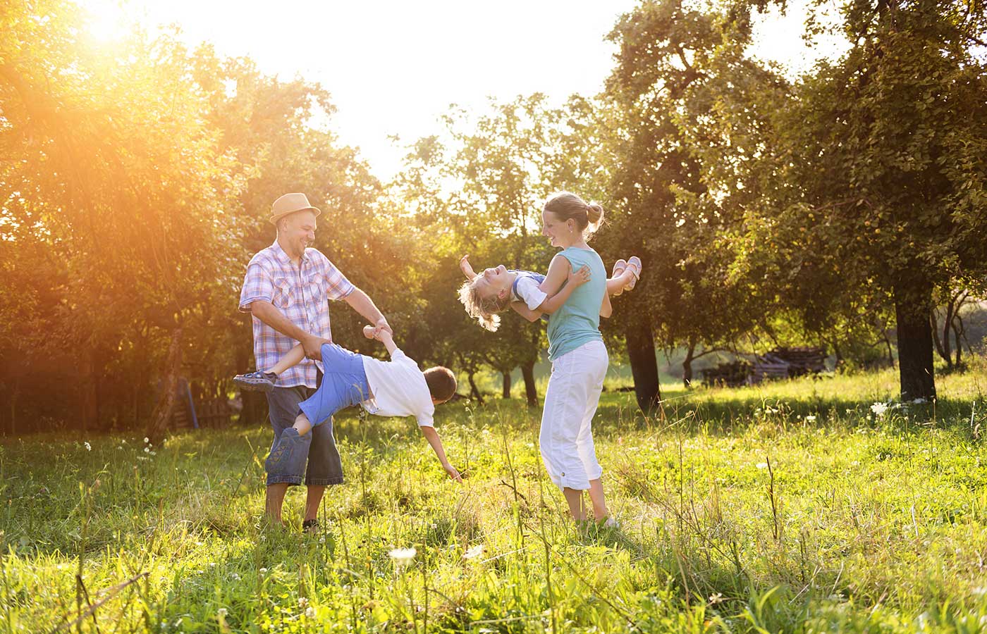 famiglia con bambini mentre gioca in un frutteto in estate