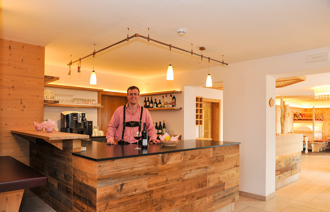 Die Bar des Hotel Der Brunnerhof im Pustertal mit dem Sohn des Hauses hinter der Theke